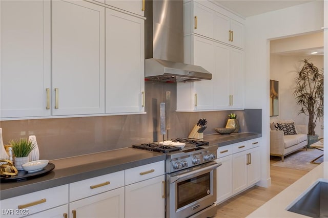 975 Amara Way, Henderson, NV 89052 - kitchen with wall chimney exhaust hood, high end stainless steel range, white cabinetry, light wood-style floors, and dark countertops