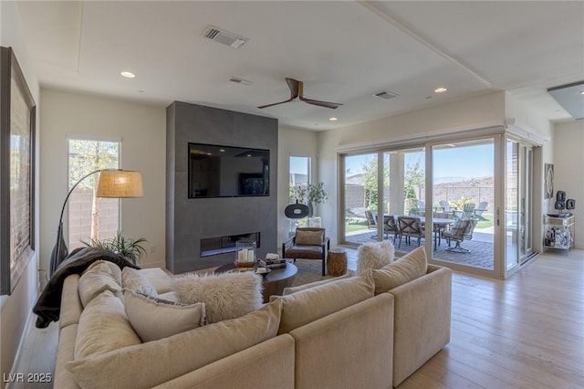 975 Amara Way, Henderson, NV 89052 - living area featuring healthy amount of natural light, a fireplace, ceiling fan, light wood-style floors, and recessed lighting