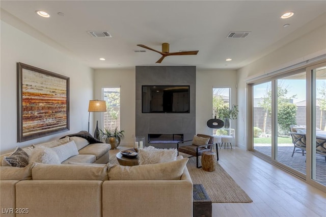 975 Amara Way, Henderson, NV 89052 - living room with a fireplace, wood finished floors, ceiling fan, and recessed lighting