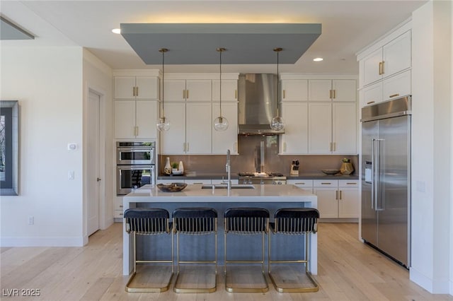 975 Amara Way, Henderson, NV 89052 - kitchen featuring stainless steel appliances, wall chimney exhaust hood, light wood-type flooring, recessed lighting, and white cabinetry