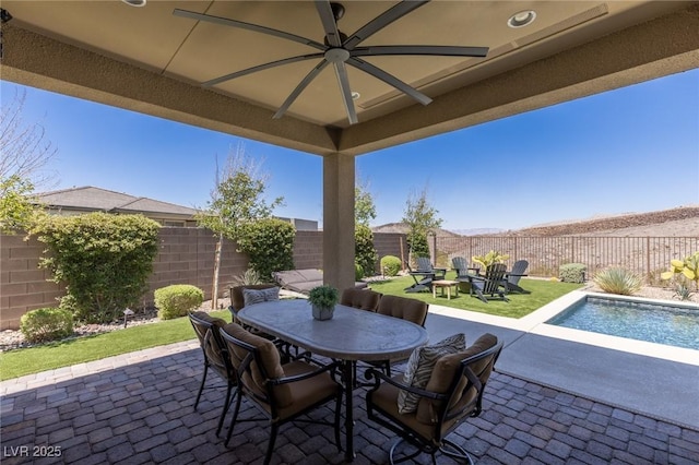 975 Amara Way, Henderson, NV 89052 - fenced backyard featuring outdoor dining area, a patio, ceiling fan, and a fire pit