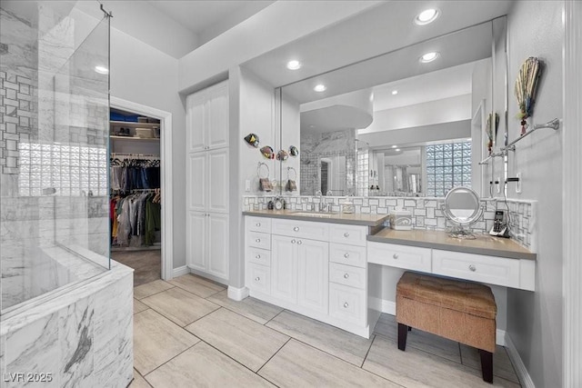108 Valiente St, Las Vegas, NV 89144 - full bathroom with vanity, a walk in shower, a spacious closet, recessed lighting, and decorative backsplash