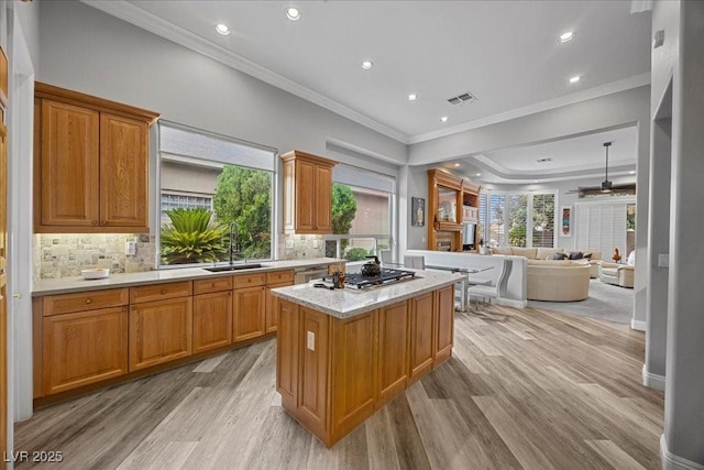 108 Valiente St, Las Vegas, NV 89144 - kitchen featuring a center island, light wood-type flooring, light countertops, ceiling fan, and crown molding