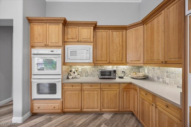 108 Valiente St, Las Vegas, NV 89144 - kitchen with white appliances, backsplash, light countertops, and light wood-style floors