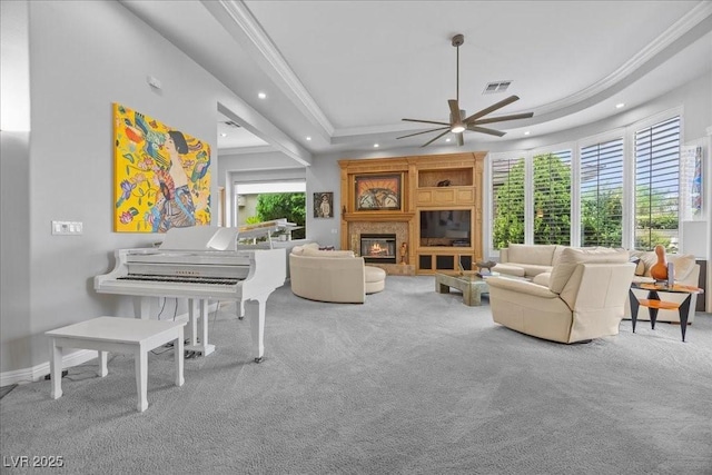 108 Valiente St, Las Vegas, NV 89144 - carpeted living room featuring a ceiling fan, a tray ceiling, recessed lighting, a glass covered fireplace, and ornamental molding