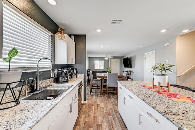 5617 Craftsman Ave, Las Vegas, NV 89122 - kitchen featuring light wood-style flooring, recessed lighting, white cabinets, and dishwasher