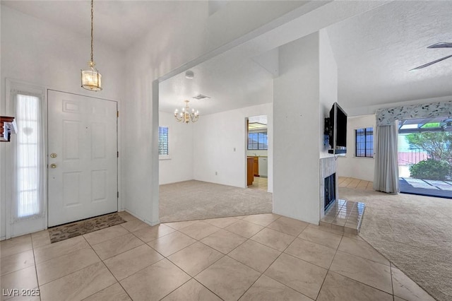 454 Intrepid Ct, Boulder City, NV 89005 - entrance foyer featuring light colored carpet, light tile patterned flooring, a chandelier, and healthy amount of natural light
