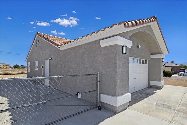 3326 Mount Charleston Dr, Pahrump, NV 89048 - view of side of home with stucco siding, a tile roof, concrete driveway, and an attached garage