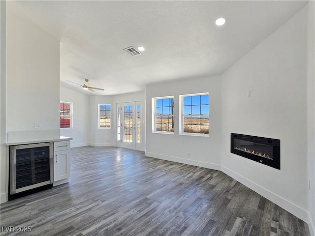 3326 Mount Charleston Dr, Pahrump, NV 89048 - unfurnished living room with beverage cooler, a glass covered fireplace, healthy amount of natural light, wood finished floors, and recessed lighting