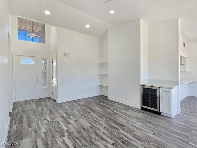 3326 Mount Charleston Dr, Pahrump, NV 89048 - unfurnished living room featuring beverage cooler, light wood-style flooring, recessed lighting, and a high ceiling