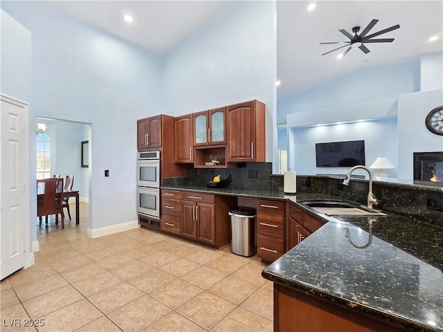 3780 Shawnee Ave, Pahrump, NV 89048 - kitchen featuring double oven, high vaulted ceiling, backsplash, light tile patterned flooring, and dark stone countertops