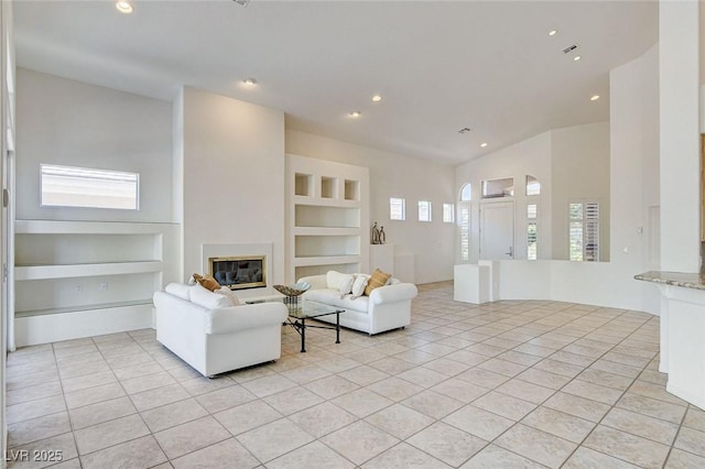 536 Pima Canyon Ct, Las Vegas, NV 89144 - living area with built in shelves, light tile patterned flooring, recessed lighting, and a glass covered fireplace