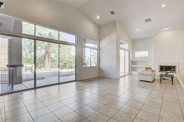 536 Pima Canyon Ct, Las Vegas, NV 89144 - unfurnished living room with tile patterned floors, high vaulted ceiling, a glass covered fireplace, and recessed lighting