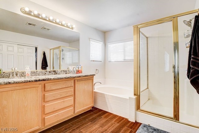 4440 Acropolis Ave, North Las Vegas, NV 89031 - full bath with double vanity, a stall shower, a bath, and wood finished floors