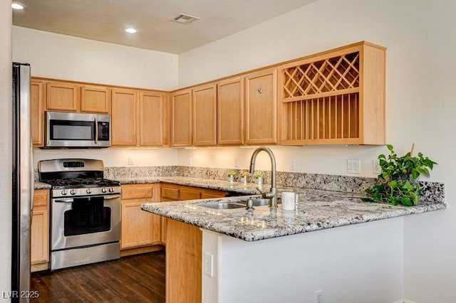 4440 Acropolis Ave, North Las Vegas, NV 89031 - kitchen with appliances with stainless steel finishes, a peninsula, dark wood-style flooring, light brown cabinetry, and recessed lighting