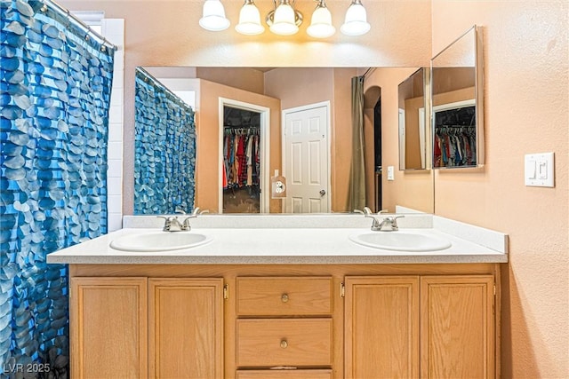 3340 N Campbell Rd, Las Vegas, NV 89129 - bathroom with double vanity, a walk in closet, and a textured wall