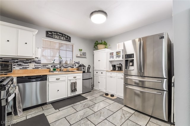 405 Box Elder Way, Henderson, NV 89015 - kitchen featuring appliances with stainless steel finishes, light countertops, white cabinets, light marble finish floors, and backsplash