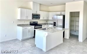 7430BO Gable Falls Pl Unit 54, North Las Vegas, NV 89084 - kitchen with stainless steel appliances, light countertops, a kitchen island with sink, and white cabinetry