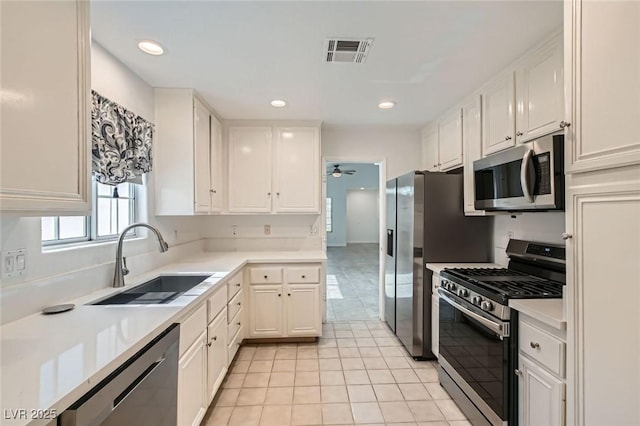 5425 Comchec Way Unit 103, Las Vegas, NV 89108 - kitchen with stainless steel appliances, white cabinetry, a ceiling fan, light tile patterned floors, and light countertops