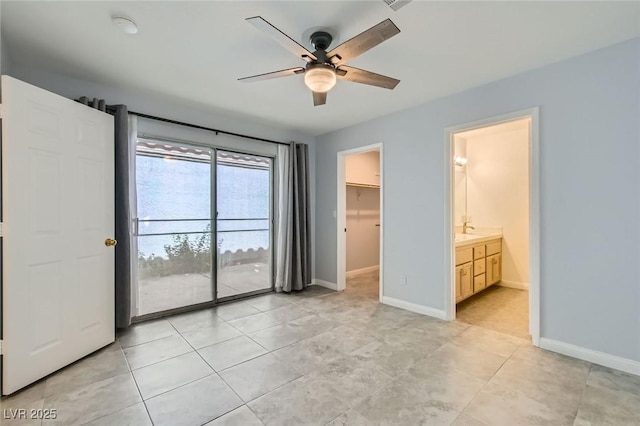 5425 Comchec Way Unit 103, Las Vegas, NV 89108 - unfurnished bedroom with a walk in closet, ensuite bathroom, light tile patterned floors, and access to outside