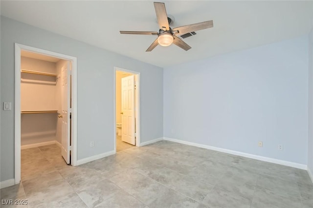 5425 Comchec Way Unit 103, Las Vegas, NV 89108 - unfurnished bedroom featuring a walk in closet, a closet, ceiling fan, ensuite bathroom, and light tile patterned flooring