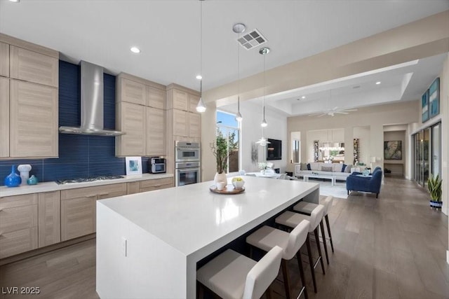 6804 Regency Stone Way, Las Vegas, NV 89148 - kitchen with wall chimney range hood, light brown cabinets, gas stovetop, double oven, and modern cabinets
