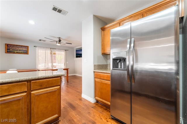 7459 Aurora Glow St, Las Vegas, NV 89139 - kitchen featuring stainless steel fridge with ice dispenser, a ceiling fan, light wood-style flooring, recessed lighting, and brown cabinetry