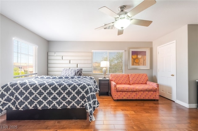 7459 Aurora Glow St, Las Vegas, NV 89139 - bedroom featuring multiple windows, wood finished floors, and a ceiling fan