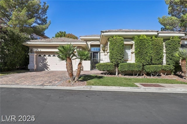 613 Pinnacle Heights Ln, Las Vegas, NV 89144 - view of front of house featuring decorative driveway, a garage, stucco siding, and a tiled roof