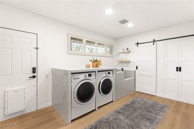 200 Stonewood Ct, Las Vegas, NV 89107 - laundry area with washer and dryer, a barn door, light wood-style floors, and recessed lighting
