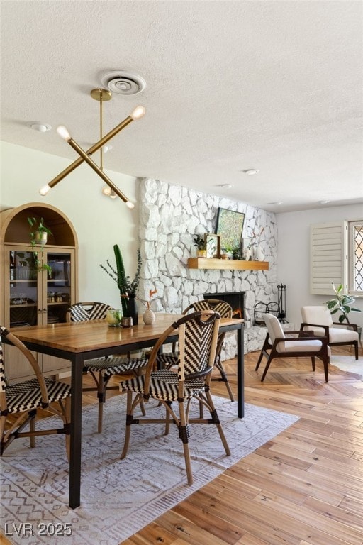 200 Stonewood Ct, Las Vegas, NV 89107 - dining space with a textured ceiling, light wood finished floors, and a fireplace