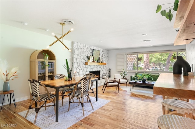 200 Stonewood Ct, Las Vegas, NV 89107 - dining space featuring a stone fireplace and light wood finished floors