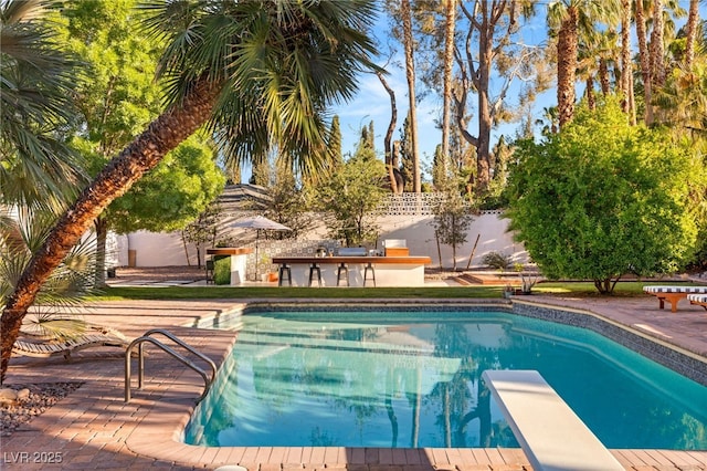 200 Stonewood Ct, Las Vegas, NV 89107 - view of pool featuring a patio area, a diving board, and exterior kitchen