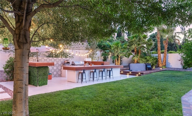 200 Stonewood Ct, Las Vegas, NV 89107 - view of grassy yard featuring an outdoor kitchen and a patio area