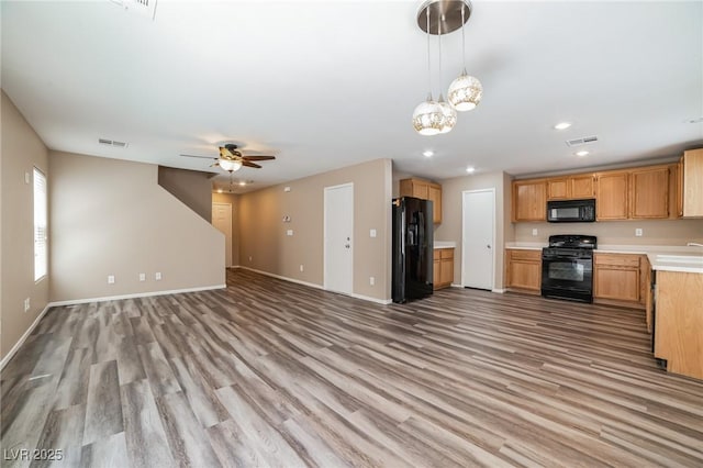 7216 Liberty Pride St, Las Vegas, NV 89148 - kitchen with black appliances, open floor plan, light wood-type flooring, light countertops, and recessed lighting