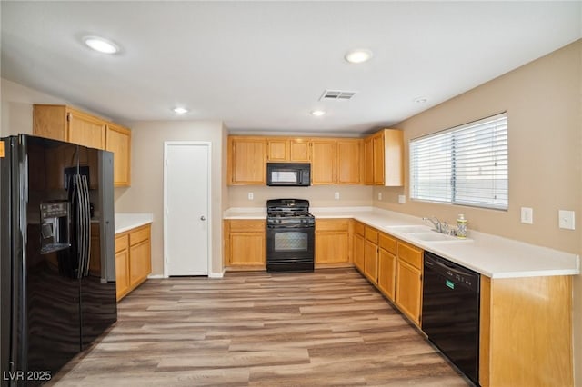 7216 Liberty Pride St, Las Vegas, NV 89148 - kitchen with black appliances, light wood finished floors, light brown cabinets, light countertops, and recessed lighting