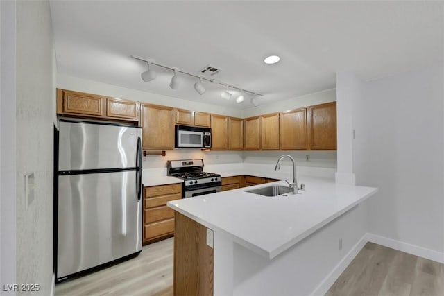 2627 S Durango Dr Unit 201, Las Vegas, NV 89117 - kitchen with stainless steel appliances, light wood finished floors, a peninsula, and light countertops