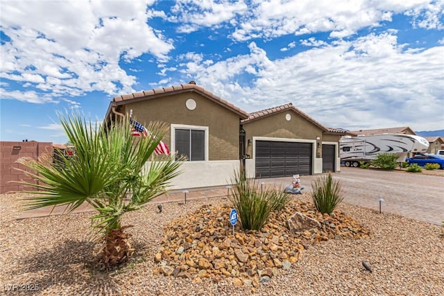 146 E Hawk Ave, Pahrump, NV 89060 - view of front of property with driveway, an attached garage, stucco siding, and a tile roof