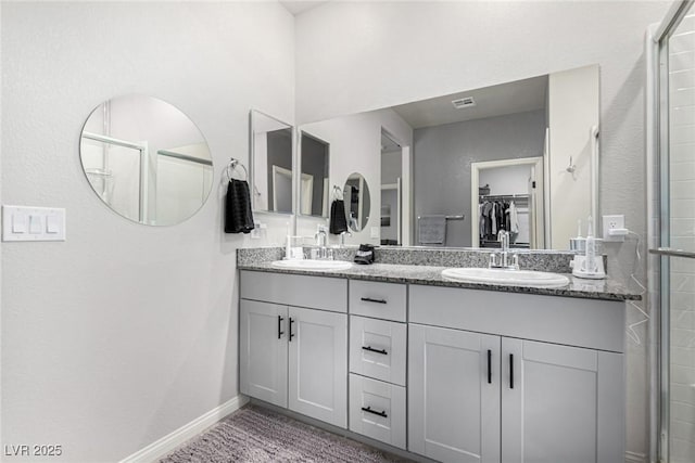 146 E Hawk Ave, Pahrump, NV 89060 - bathroom with double vanity, a spacious closet, and a tile shower