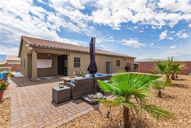 146 E Hawk Ave, Pahrump, NV 89060 - back of house with stucco siding, a tiled roof, a fenced backyard, and a patio area