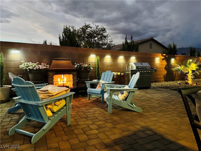 146 E Hawk Ave, Pahrump, NV 89060 - view of patio / terrace featuring a warm lit fireplace and grilling area