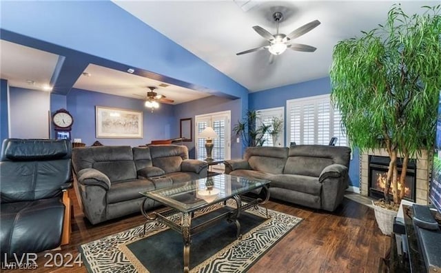 2253 Van Gogh Dr, Henderson, NV 89074 - living room with a ceiling fan, a lit fireplace, vaulted ceiling, and dark wood-style floors