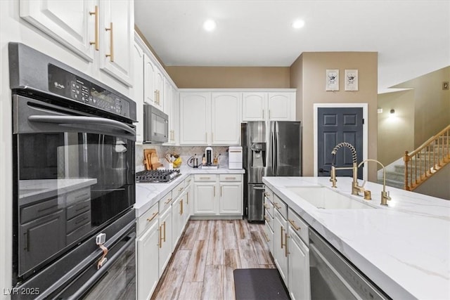 8929 Monte Oro Dr, Las Vegas, NV 89131 - kitchen with black appliances, white cabinetry, light stone counters, decorative backsplash, and recessed lighting