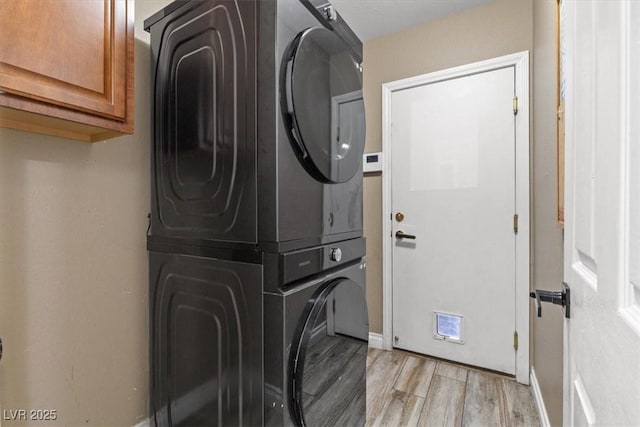 8929 Monte Oro Dr, Las Vegas, NV 89131 - washroom with stacked washing machine and dryer, cabinet space, and light wood finished floors