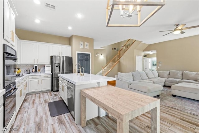 8929 Monte Oro Dr, Las Vegas, NV 89131 - kitchen with stainless steel appliances, light wood finished floors, light countertops, white cabinetry, and recessed lighting