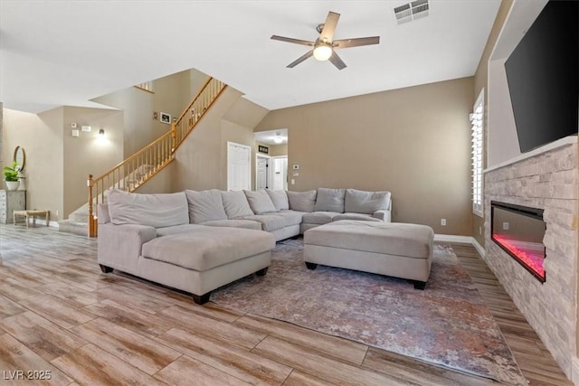 8929 Monte Oro Dr, Las Vegas, NV 89131 - living room with wood finished floors, stairs, a ceiling fan, and a stone fireplace