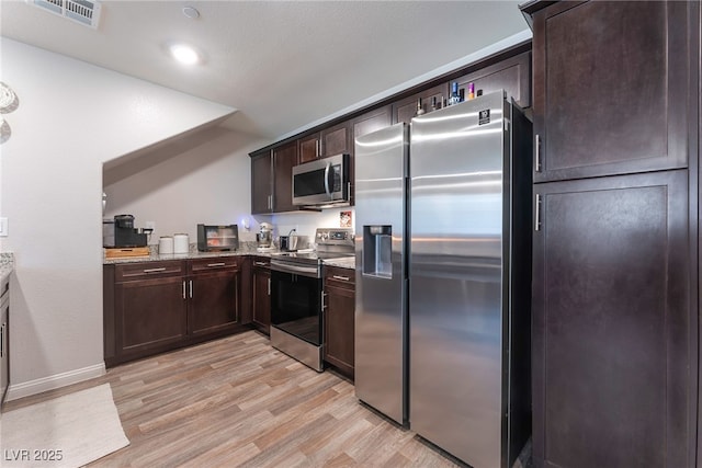2620 Canary Yellow Ct, North Las Vegas, NV 89086 - kitchen with appliances with stainless steel finishes, light wood-style flooring, dark brown cabinets, light stone counters, and recessed lighting