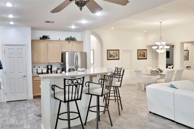 11240 Romette Ct, Las Vegas, NV 89141 - kitchen with freestanding refrigerator, light brown cabinets, a ceiling fan, light wood-style flooring, and a kitchen breakfast bar