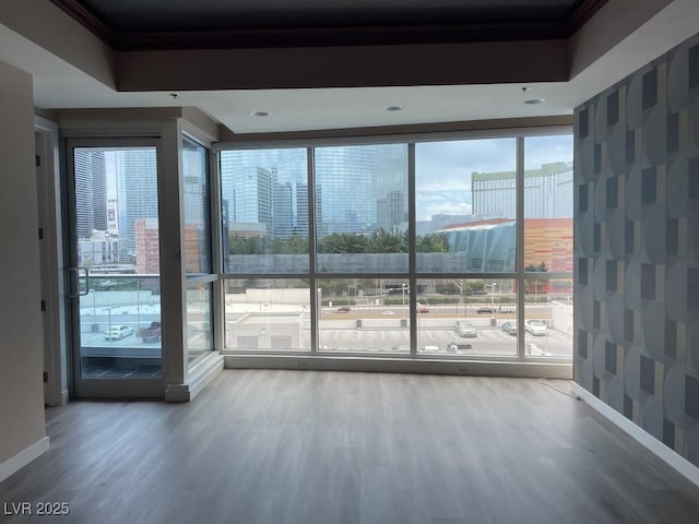 4575 Dean Martin Dr Unit 705, Las Vegas, NV 89103 - unfurnished room featuring wood finished floors, plenty of natural light, a city view, and ornamental molding