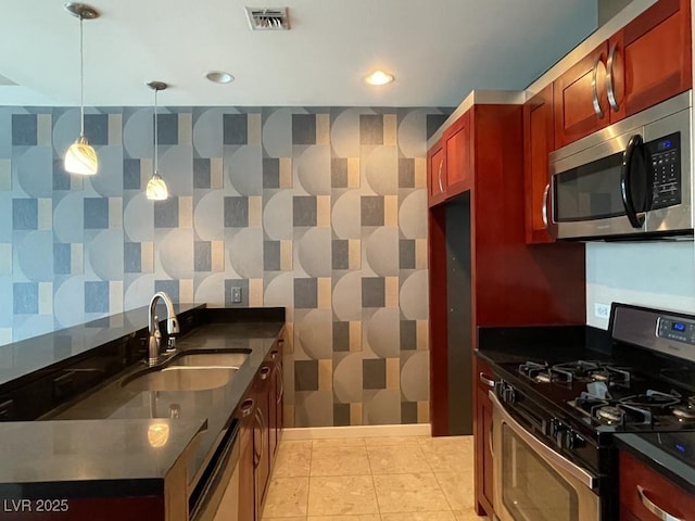 4575 Dean Martin Dr Unit 705, Las Vegas, NV 89103 - kitchen with stainless steel appliances, dark countertops, reddish brown cabinets, pendant lighting, and recessed lighting